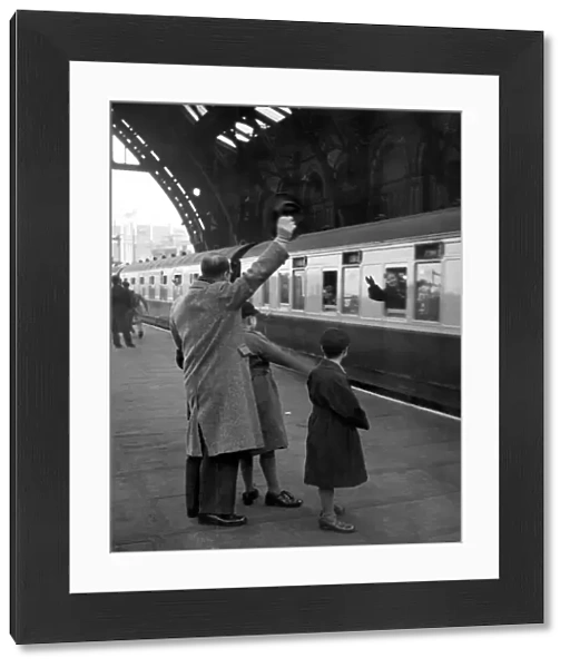 Train leaving St Pancras Station 1940 s. Father and sons waving goodbye from the platform