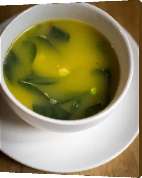 Light fresh soup made of lobster stock with saffron, prawns, peas and baby spinach