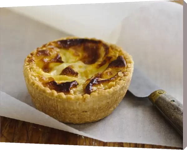 Little Quiche Lorraine on curled greaseproof paper with knife credit: Marie-Louise