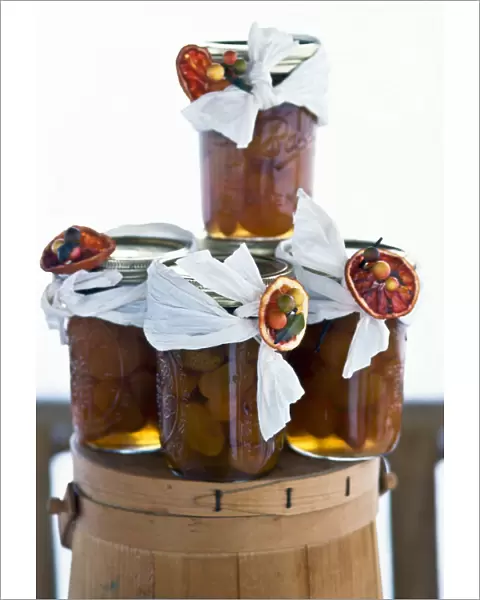 Jars of spiced dried apricots in brandy, decorated as christmas gifts. credit