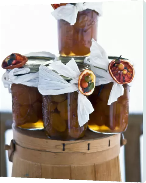 Jars of spiced dried apricots in brandy, decorated as christmas gifts. credit