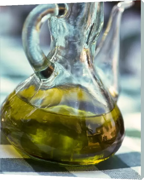Bottle of olive oil on outdoor restaurant table in southern France, with reflection