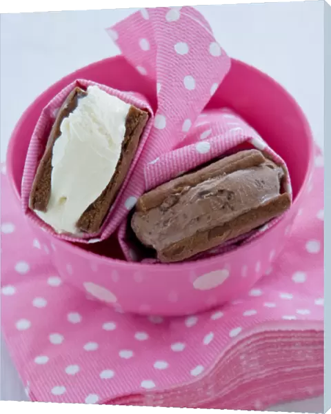 Chocolate and vanilla icecream in homemade chocolate biscuits wrapped in spotty pink