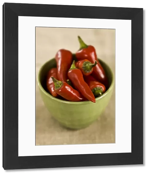 Red hot chilli peppers in green bowl credit: Marie-Louise Avery  /  thePictureKitchen