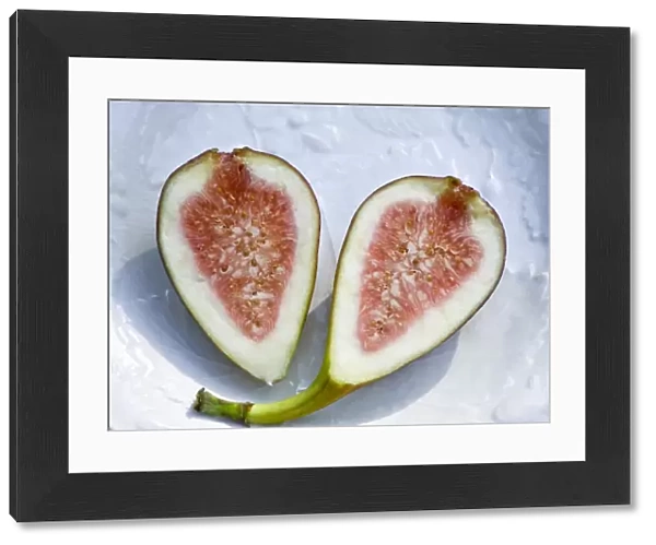 Halved ripe fig on white plate credit: Marie-Louise Avery  /  thePictureKitchen  /  TopFoto