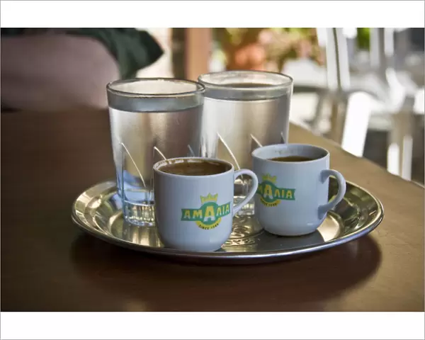 Two little cups of Greek coffee with accompanying glasses of water served in Cypriot