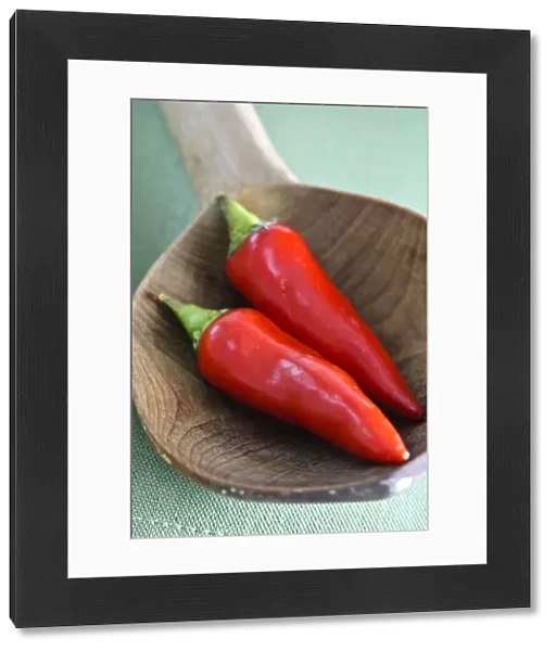 Shiny red chilli peppers in big wooden spoon credit: Marie-Louise Avery  /  thePictureKitchen