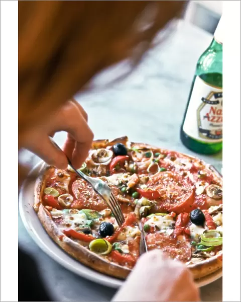 Eating pizza in Pizza Express restaurant, with bottle of Nastro Azzuro beer. credit
