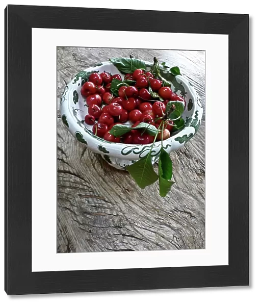 Freshly picked cherries from a Kentish garden in decorative pedestal bowl on rustic