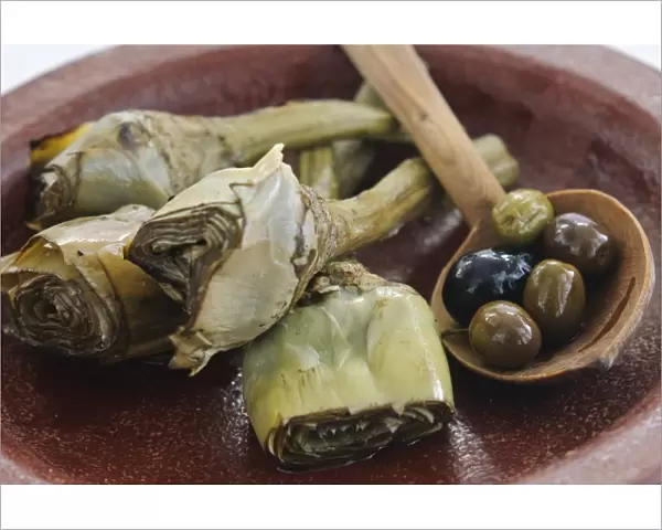 Italian grilled and marinated artichokes on brown dish credit: Marie-Louise Avery