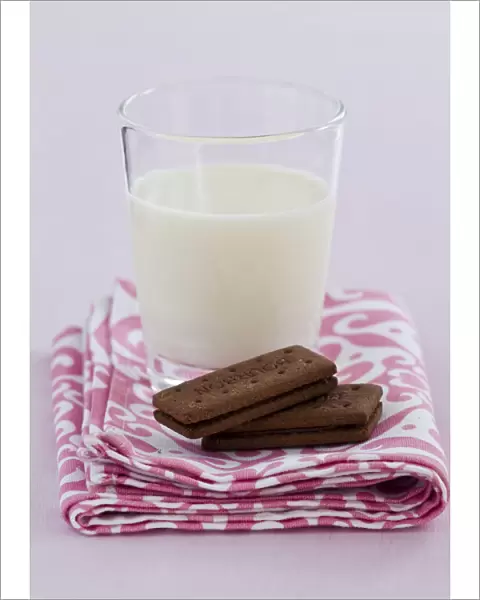 Bedtime snack of a glass of cold fresh milk with bourbon chocolate biscuits credit
