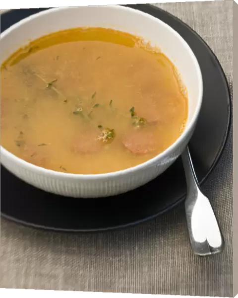 Bowl of warming soup made of yellow split peas, good stock, pieces of chorizo sausage