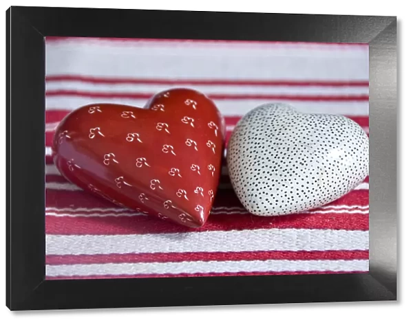 Two heart shaped soapstone paperweights, on striped table runner. credit: Marie-Louise