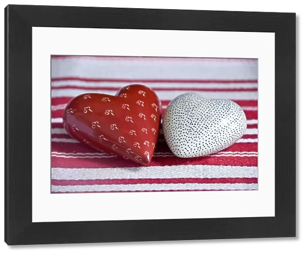 Two heart shaped soapstone paperweights, on striped table runner. credit: Marie-Louise