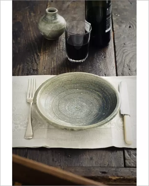Rustic table setting with tumbler of red wine before food arrives credit: Marie-Louise
