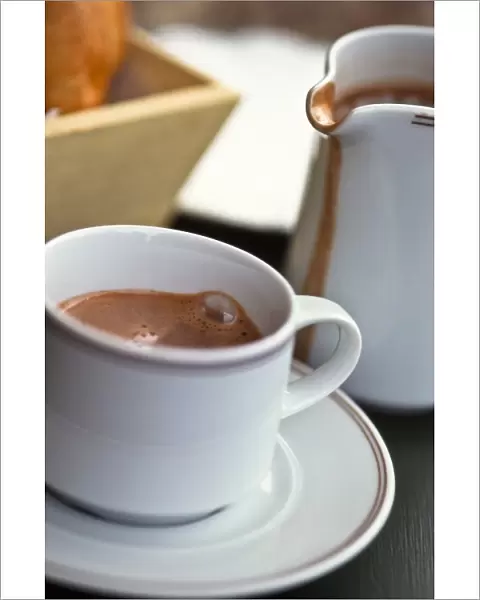 Jug and cup of hot drinking chocolate, on French cafe table credit: Marie-Louise