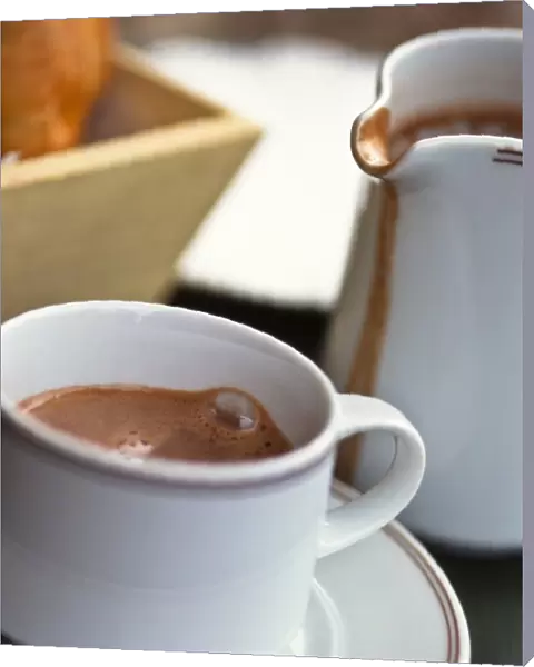 Jug and cup of hot drinking chocolate, on French cafe table credit: Marie-Louise