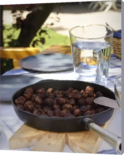 Frying pan of Swedish meatballs on table outside in dappled summer sunshine credit