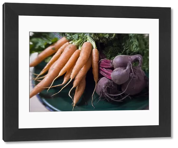 Bunches of fresh carrots and beetroot on dark green platter credit: Marie-Louise