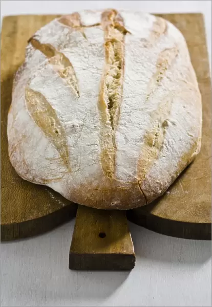 Organic rustic white loaf on wooden cutting board credit: Marie-Louise Avery  / 