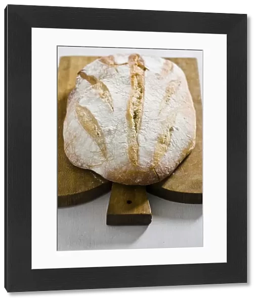 Organic rustic white loaf on wooden cutting board credit: Marie-Louise Avery  / 