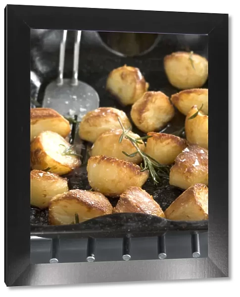 Roast potatoes in black roasting tin with salt and rosemary credit: Marie-Louise