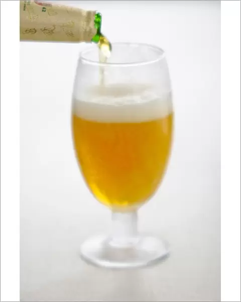 Pouring lager beer into stemmed beer glass credit: Marie-Louise Avery  /  thePictureKitchen