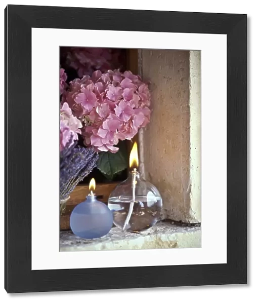 Two oil burner lamps with pink hydrangea and lavender in window niche credit: Marie-Louise