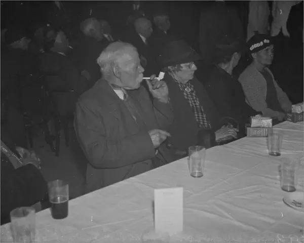 An elderly gentleman smokes his clay pipe at the old folks party at Crayford, Kent