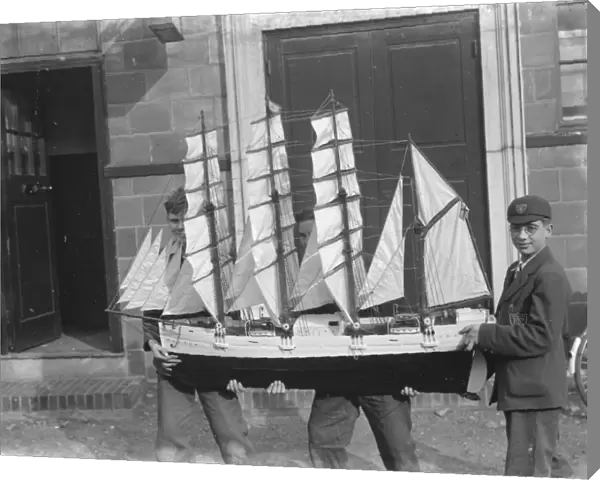 Boys hold up a model sailing ship at the handicraft exhibition in Dartford, Kent