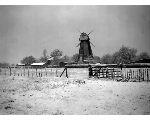 Windmill in white after early snow. Surrounded by a carpet of crisp powdery snow