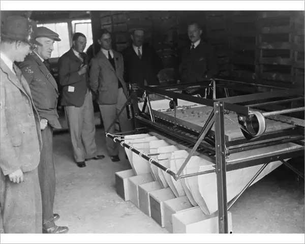 Farmers looking at machinery for fruit grading at the fruit farm. 1935