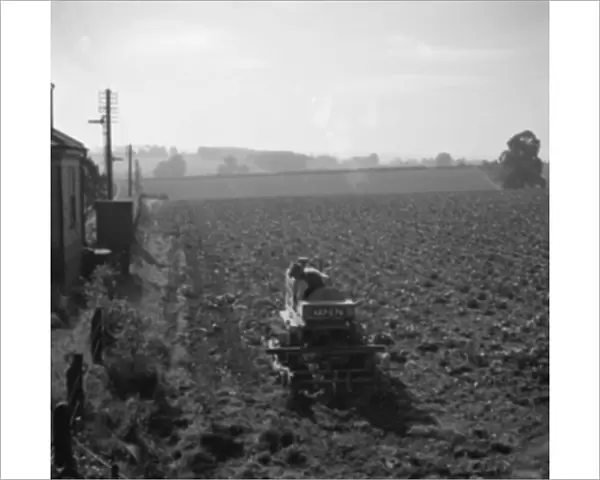 A farmer on a tractor ploughing a field. 1936