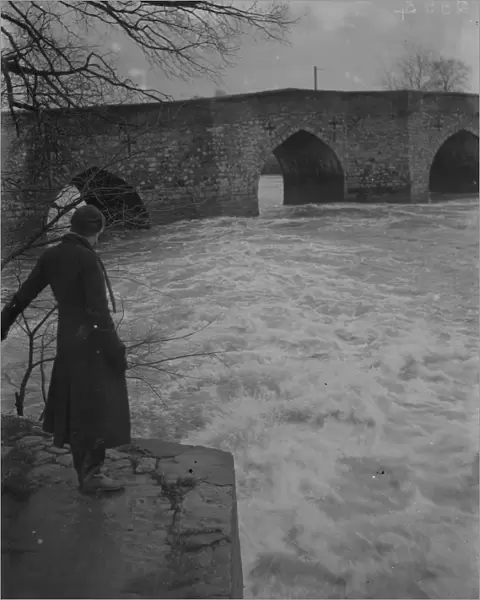 A full, rushing river at the ancient stone bridge at Yalding in Kent after flooding