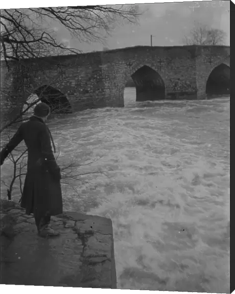 A full, rushing river at the ancient stone bridge at Yalding in Kent after flooding