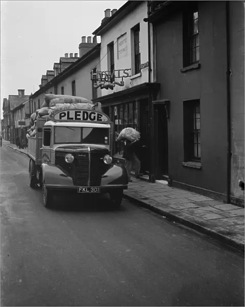 Workers are unloading sacks of flour from a Bedford truck belonging to Pledge & Son Ltd