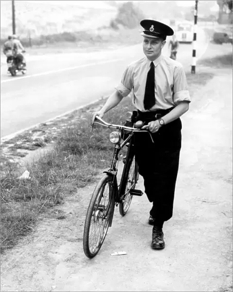 A Kent police officer with his bicycle. 26th July 1952