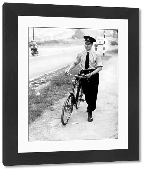 A Kent police officer with his bicycle. 26th July 1952