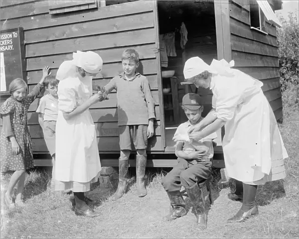 Nurses tending to injured children at the Hop pickers dispensary at Faversham, Kent