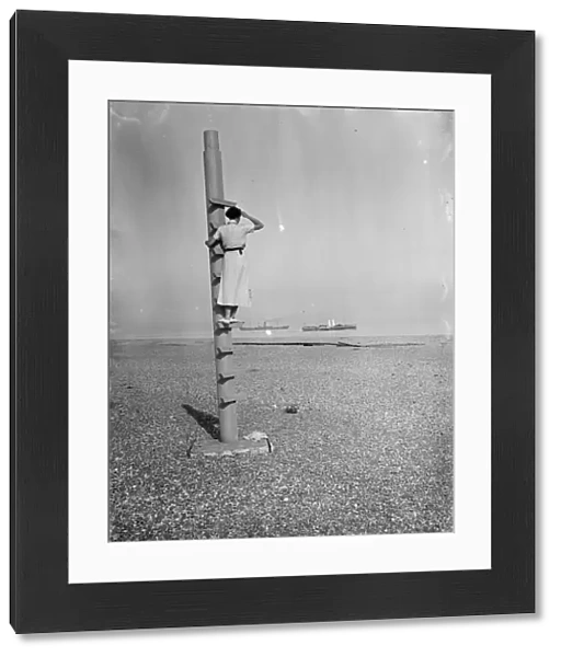 A woman stands on the outlook post on Dungeness beach in Kent. 1936