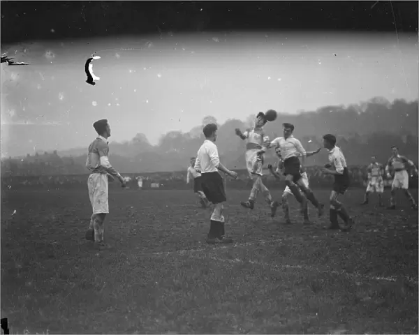 Boys football, two players compete for an aerial ball. 1935