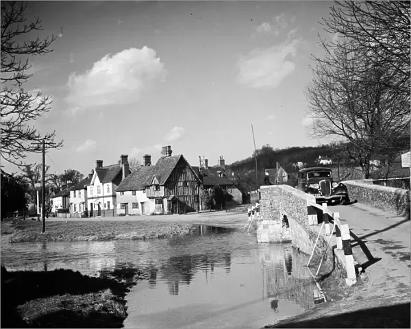 A view of Eynsford with a car coming over the bridge by the ford over the River Darent