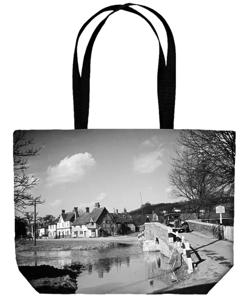 A view of Eynsford with a car coming over the bridge by the ford over the River Darent