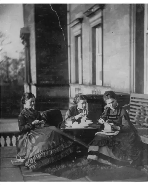 Mother and daughters enjoy their tea outdoors in the afternoon sun