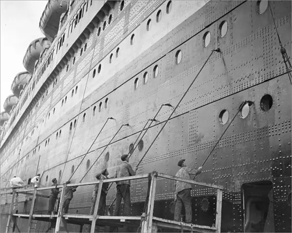 Painters dwarfed by the bulk of the Queen Elizabeth, the worlds largest liner