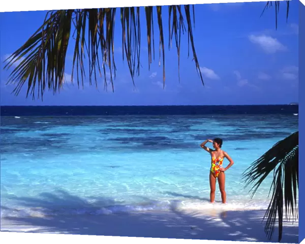 Girl standing on beach of the island of Bandos, in the Maldives