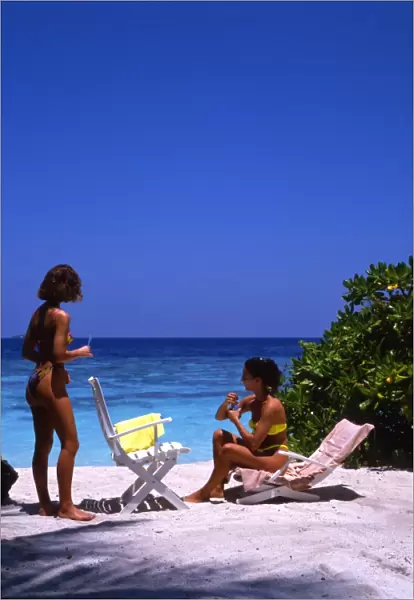 Two young women on the beach of Bandos Island, the Maldives