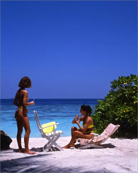 Two young women on the beach of Bandos Island, the Maldives