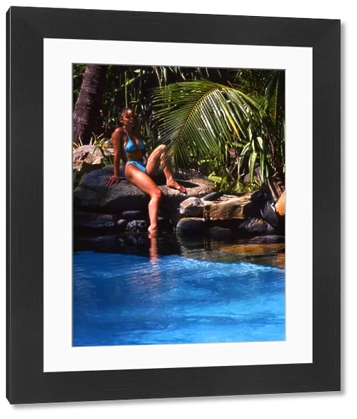 Girl seated by pool in Brampton Island resort, the Great Barrier Reef, Australia