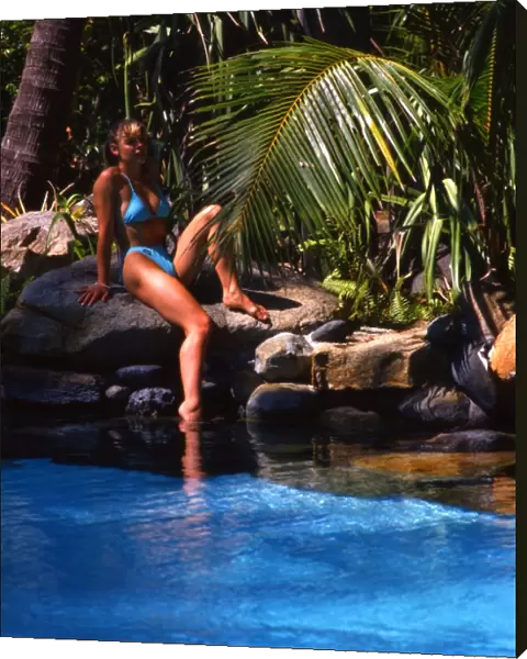 Girl seated by pool in Brampton Island resort, the Great Barrier Reef, Australia